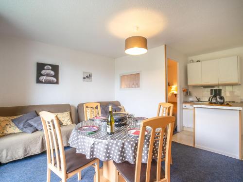 un salon avec une table et des chaises et une cuisine dans l'établissement Apartment Vostok Zodiaque-52 by Interhome, au Corbier