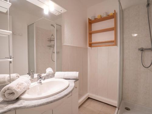 une salle de bain blanche avec un lavabo et une douche dans l'établissement Apartment Vostok Zodiaque-52 by Interhome, au Corbier