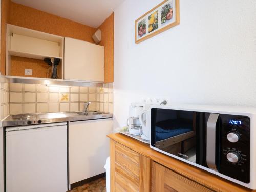- une cuisine avec un four micro-ondes sur une armoire en bois dans l'établissement Apartment Astragale 412 A by Interhome, aux Menuires