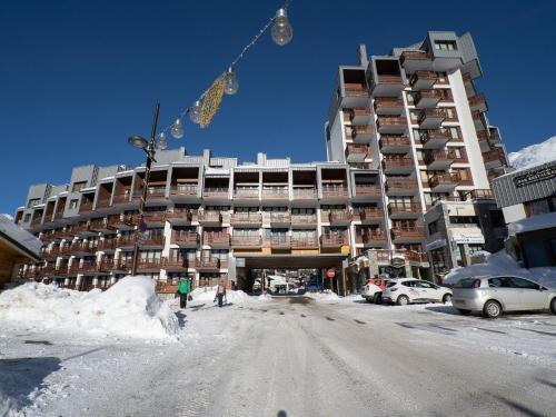 un grand bâtiment dans une rue enneigée avec des voitures garées devant dans l'établissement Apartment Le Curling B - Val Claret-21 by Interhome, à Tignes