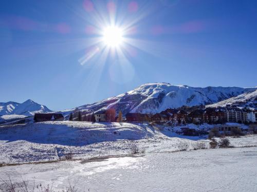 a snow covered mountain with the sun in the sky at Apartment Plein Soleil-1 by Interhome in La Toussuire