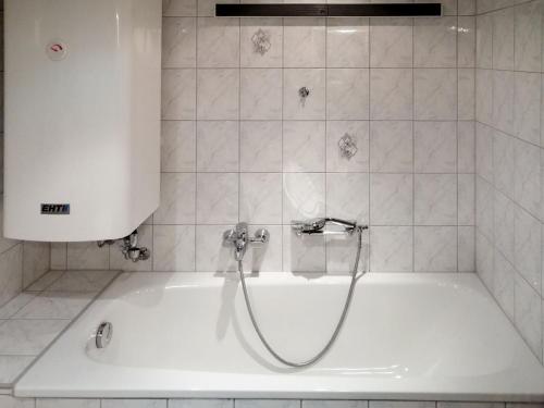 a white bath tub with a shower in a bathroom at Holiday Home Waldruh by Interhome in Telfs