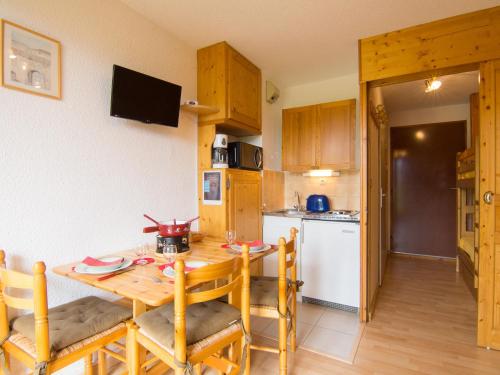 une cuisine et une salle à manger avec une table et des chaises en bois dans l'établissement Apartment Plein Soleil-3 by Interhome, à La Toussuire