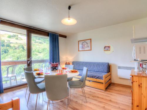 un salon avec une table, des chaises et un canapé dans l'établissement Apartment Vostok Zodiaque-55 by Interhome, au Corbier