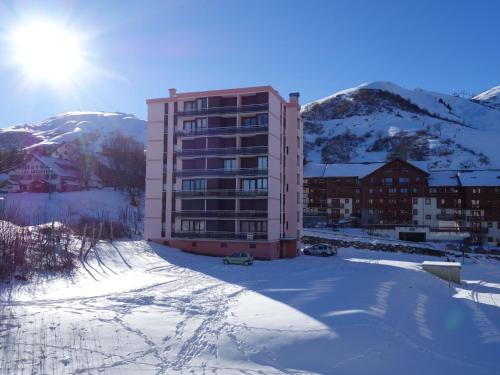un bâtiment dans la neige devant une montagne dans l'établissement Apartment Bellard-1 by Interhome, à La Toussuire