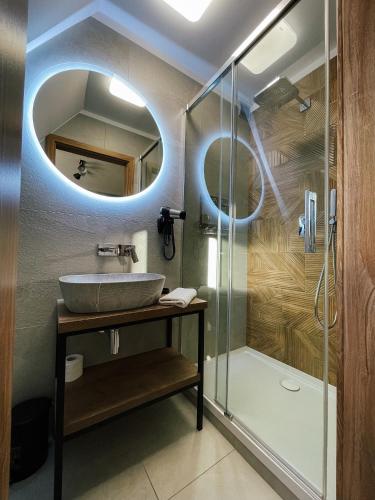 a bathroom with a sink and a shower at Willa Pachówka - tam, gdzie natura spotyka się z nowoczesnością in Bukowina Tatrzańska