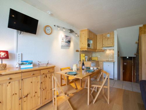Una cocina con una mesa de madera y un comedor. en Apartment Brelin Evons 401 by Interhome, en Les Menuires