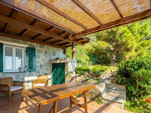 une table en bois sur une terrasse avec pergola en bois dans l'établissement Holiday Home Villa Monilia by Interhome, à Moneglia