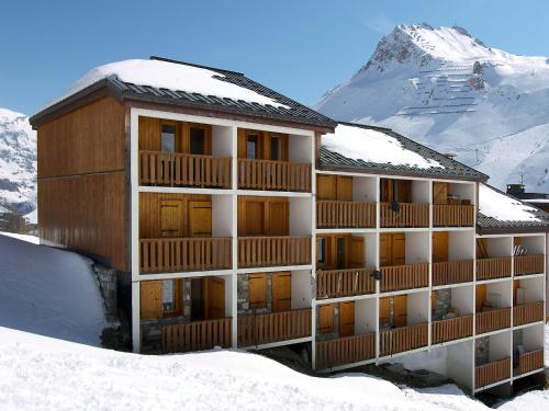 a building in the snow with a mountain in the background at Apartment La Divaria-6 in Tignes