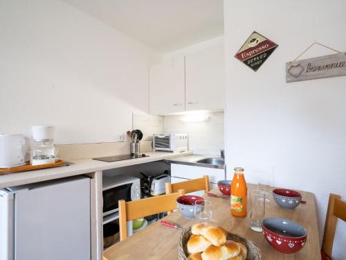una cocina con una mesa con pan. en Apartment Les Asters-30 by Interhome en Les Menuires