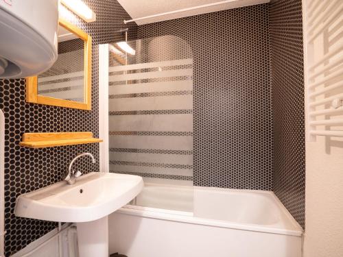 a bathroom with a sink and a bath tub at Apartment Les Asters-30 by Interhome in Les Menuires