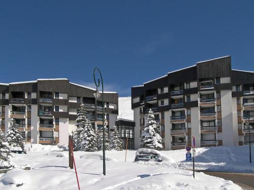 a apartment building in the snow with snow covered trees at Apartment Les Mélèzes-5 by Interhome in Les Menuires