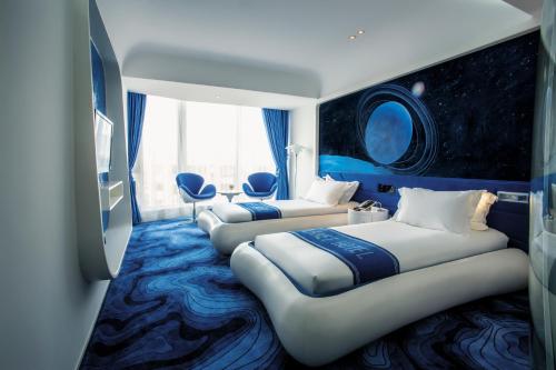 Guangzhou Planet Hotel tesisinde bir odada yatak veya yataklar