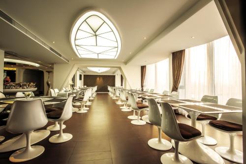 a dining room with tables and chairs and a window at Guangzhou Planet Hotel in Guangzhou