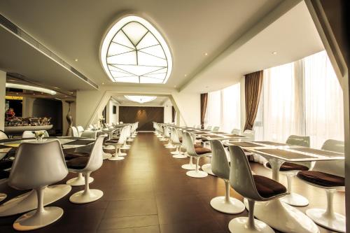فندق قوانغتشو بلانيت في قوانغتشو: غرفة طعام بها طاولات وكراسي ونافذة