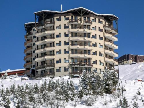 un gran edificio de apartamentos en lo alto de una ladera cubierta de nieve en Studio Le Médian-4 by Interhome, en Les Menuires