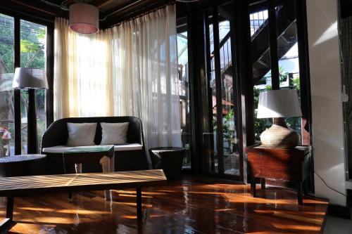 a living room with a couch and a table at Kampaeng Ngam Hotel in Chiang Mai