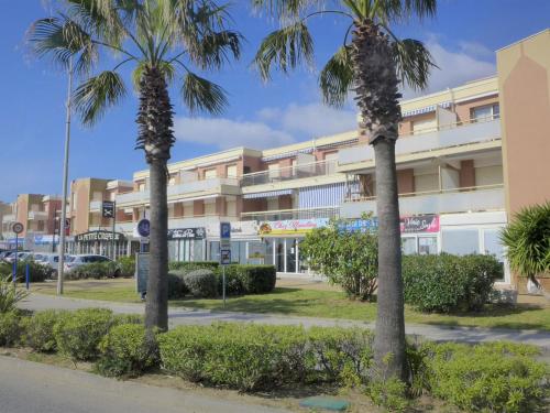 two palm trees in front of a building at Apartment La Croix du Sud-4 by Interhome in Cavalaire-sur-Mer