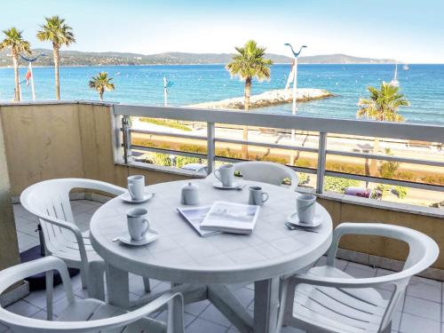une table et des chaises sur un balcon avec vue sur la plage dans l'établissement Apartment Le Palazzo del Mar-5 by Interhome, à Cavalaire-sur-Mer
