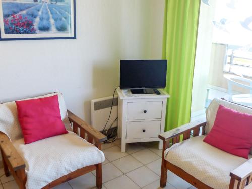 un salon avec deux chaises et une télévision dans l'établissement Apartment Le Palazzo del Mar-5 by Interhome, à Cavalaire-sur-Mer