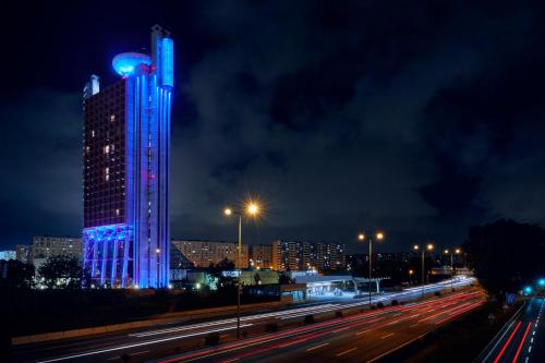 a tall building with blue lights on it at night at Hyatt Regency Barcelona Tower in Hospitalet de Llobregat