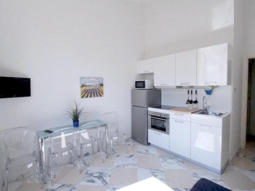 a kitchen with white cabinets and a table and chairs at Apartment Bufalini 3 - Michelangelo by Interhome in Florence