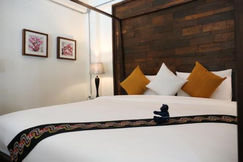 a bedroom with a large bed with yellow and white pillows at Kampaeng Ngam Hotel in Chiang Mai