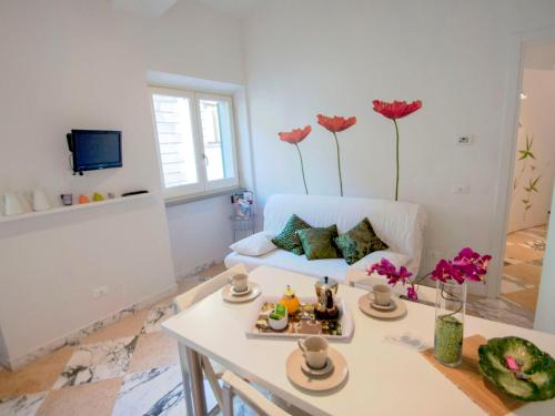 a living room with a white couch and flowers on the wall at Apartment Bufalini 2 - Raffaello by Interhome in Florence