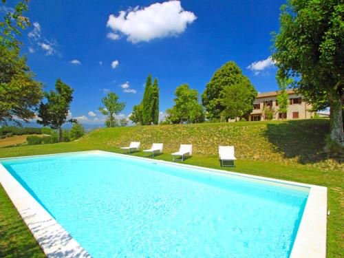 a swimming pool with chairs and a house at Holiday Home Montebello by Interhome in Monterchi