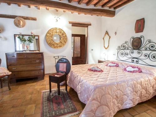 a bedroom with a large bed and a dresser at Holiday Home Poggio Velluto by Interhome in Seggiano