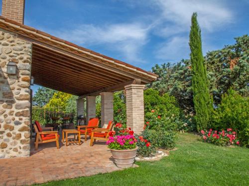a patio with chairs and flowers in a yard at Apartment Allerona-3 by Interhome in Allerona