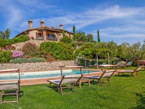 a group of chairs sitting in the grass by a pool at Apartment Allerona-3 by Interhome in Allerona
