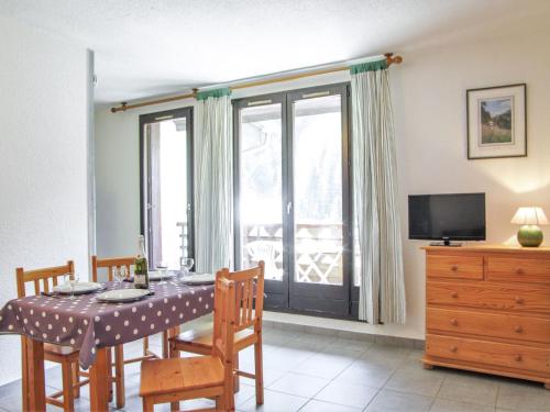 une salle à manger avec une table et des chaises et une fenêtre dans l'établissement Apartment Gentiane-3 by Interhome, à Chamonix-Mont-Blanc