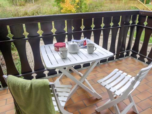 d'une table blanche et de deux chaises sur un balcon. dans l'établissement Apartment Clos du Savoy-15 by Interhome, à Chamonix-Mont-Blanc