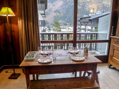 - une table avec des verres à vin sur le balcon dans l'établissement Apartment Le Brévent-14 by Interhome, à Chamonix-Mont-Blanc