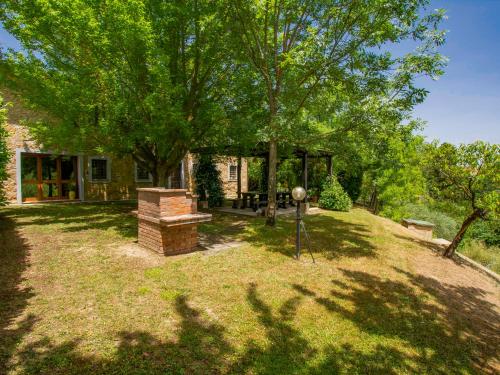 a house with a tree and a grill in the yard at Holiday Home Casa dei Ciliegi by Interhome in Querce