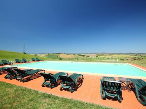 a group of chairs sitting next to a swimming pool at Apartment B1 by Interhome in Casetta