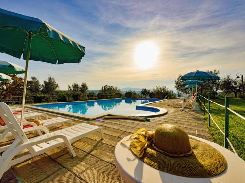 a hat sitting on a table next to a swimming pool at Holiday Home Malagronda-1 by Interhome in Ravigliano