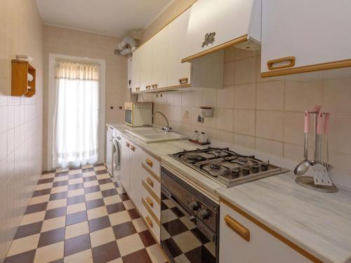 a kitchen with a stove and a checkered floor at Apartment Edificio Garcomar I by Interhome in Segur de Calafell