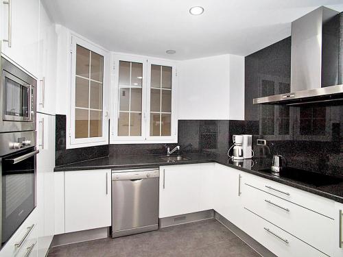 a kitchen with white cabinets and a stainless steel dishwasher at Apartment Eixample Esquerre Gran Via Balmes by Interhome in Barcelona