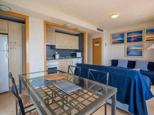 cocina y sala de estar con mesa de cristal y sillas. en Apartment Punta Cormoran by Interhome, en La Manga del Mar Menor
