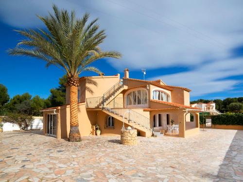 a palm tree in front of a house at Villa Campos by Interhome in Calpe