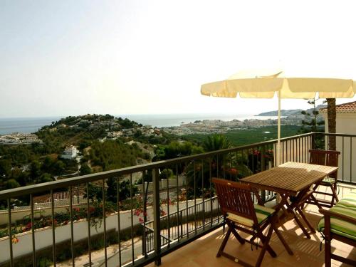 a balcony with a table and chairs and an umbrella at Apartment Las Fuentes by Interhome in Almuñécar