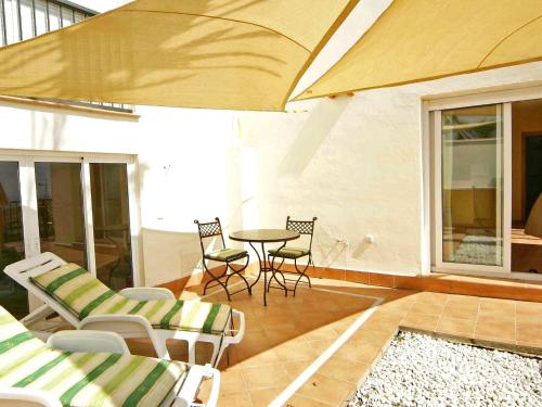 a patio with chairs and a table and a table at Apartment Las Fuentes by Interhome in Almuñécar