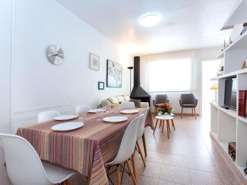 a dining room with a table and white chairs at Holiday Home El Palmar Playa Romana by Interhome in Alcossebre