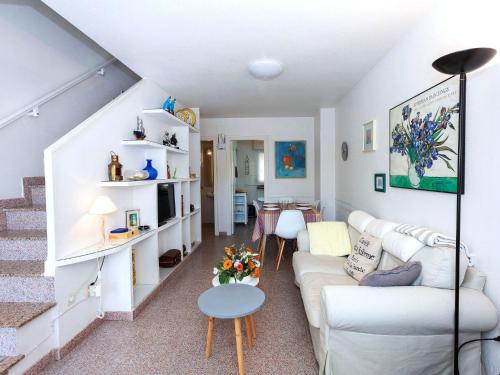a living room with a white couch and a table at Holiday Home El Palmar Playa Romana by Interhome in Alcossebre