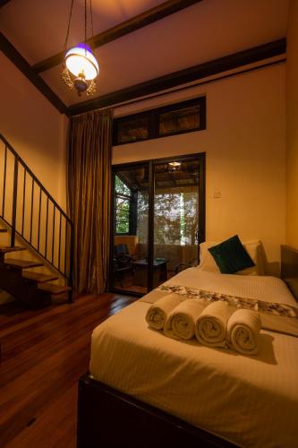 a bedroom with a bed with rolled towels on it at Spices Hotel in George Town