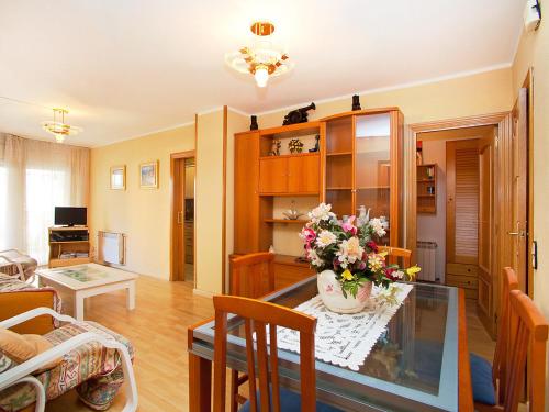 una sala de estar con una mesa con un jarrón de flores. en Apartment Edificio Blanqueries by Interhome, en Calella