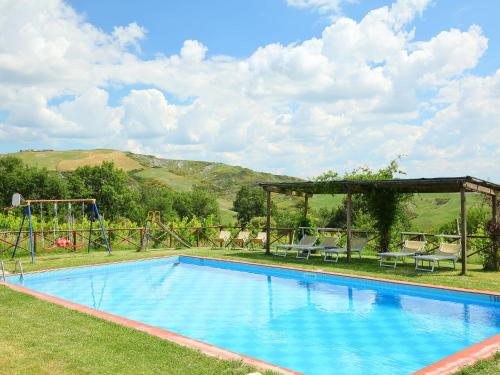 a large swimming pool with a pavilion and a playground at Holiday Home Val d'Orcia by Interhome in Radicofani