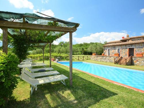 Holiday Home Val d'Orcia by Interhome في راديكوفاني: صف كراسي الصالة بجانب المسبح